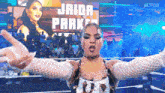 a woman in a wrestling ring with the name jaida parker on a screen behind her