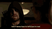 a man in a hooded jacket is talking to another man in a red shirt .