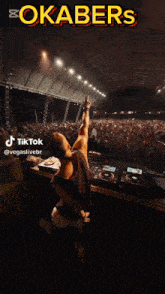 a dj playing music in front of a crowd with the words okabers on the bottom