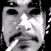 a close up of a man smoking a cigarette