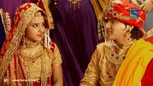 a bride and groom are looking at each other with a sony television logo on the bottom right
