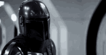 a black and white photo of a man wearing a helmet and armor .