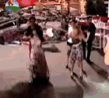 a group of people are standing on a sidewalk holding umbrellas .