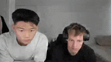 two men are sitting next to each other wearing headphones .