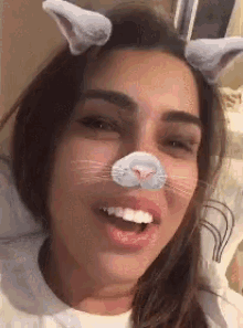a woman wearing a cat mask with ears on her head is smiling .