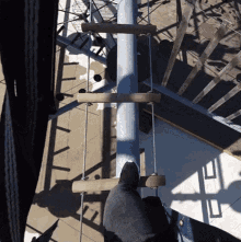 a person climbs a wooden ladder with the letter e on the bottom