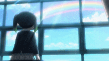 a girl is looking out a window at a rainbow