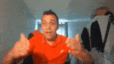 a man wearing a red nike polo shirt is making a funny face