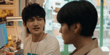two young men are standing next to each other and one of them is making a funny face .