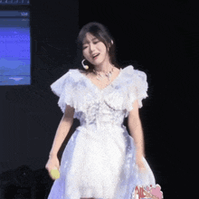 a woman in a white dress is holding a sign that says all
