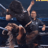 a referee watches two women wrestle in a smack down wrestling ring