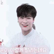 a young man is smiling and holding a brush in his hand with korean writing around his head