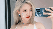 a woman is taking a picture of herself with a phone that has stickers on it that say i love you