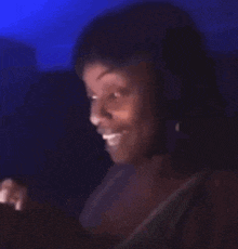 a woman is smiling while looking at her phone