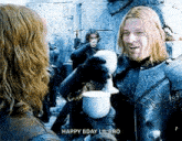 a man in a knight 's armor is holding a cup of coffee while talking to another man .