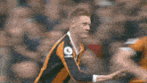 a soccer player wearing an orange and black jersey with a uefa logo on the sleeve