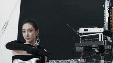 a woman in a black and silver dress is standing in front of a machine .