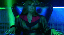 a woman is sitting in a chair in a dark room with a green background .