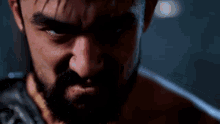 a close up of a man 's face with a beard and a sword in his hand .