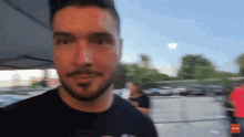 a man with a beard and mustache is wearing a black t-shirt that says ' miami ' on the front