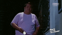 a man in a purple shirt is holding a flashlight in front of a sign that says astro citix