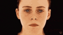 a close up of a woman 's face with her mouth open and her tongue sticking out
