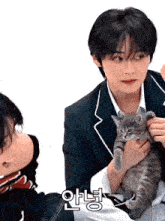 a man in a suit is holding a small kitten in his arms .