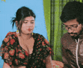 a man and a woman are sitting next to each other and the woman has a very large breast