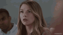a woman is making a surprised face while sitting in front of a man .