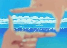 two hands are making a frame with their fingers against a blue sky