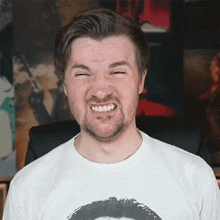 a man wearing a white shirt with a picture of a man on it making a funny face