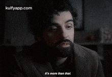 a man with a beard is sitting in a dark room and says it 's more than that .