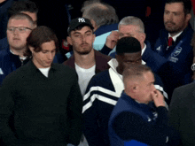 a man wearing a new york yankees hat walks through a crowd