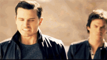 two men are standing next to each other and one of them is making a funny face