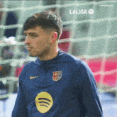 a man wearing a laliga shirt is standing in front of a goal .