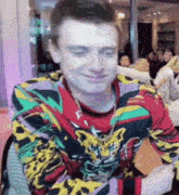 a man wearing a colorful shirt with a tiger on it is smiling .