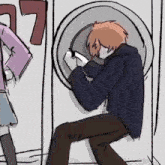 a man is sitting in a washing machine while a woman looks on .