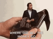 a person is holding a wallet with a picture of a man in it and the words `` where did all the money go '' .