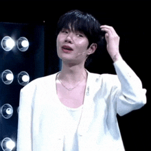 a man in a white jacket is scratching his hair