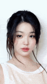 a woman with long black hair is wearing a white top