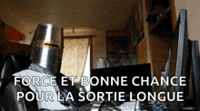 a man wearing a knight 's helmet sits in front of a computer screen with the words force et bonne chance
