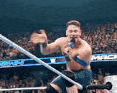 a man in a wrestling ring holds a microphone in front of a sign that says " mack "