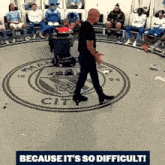 a man walking in a circle with a man city logo on it