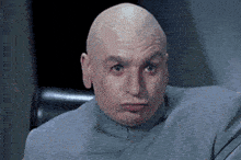 a bald man is sitting in a chair with his eyes closed .