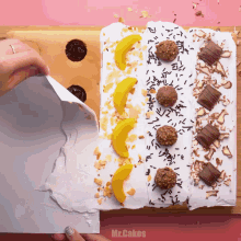 a person is decorating a cake with mr.cakes written on the bottom right corner