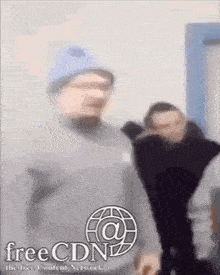 a man wearing a blue hat is standing in front of a free cdn logo .