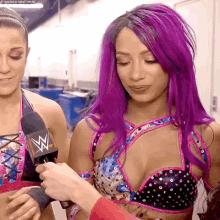 a wrestler with purple hair is being interviewed