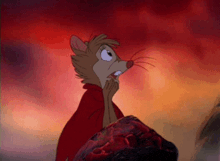 a cartoon mouse is standing on a rock and looking up at the sky .