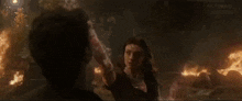 a man and a woman are standing next to each other in a fire .