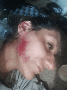 a woman with red lipstick on her face has the word i love you written on her neck